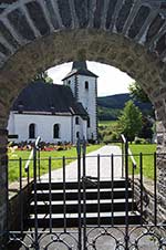 Blick durch das Friedhostor auf die Pfarrkirche St. Vincentius in Lenne