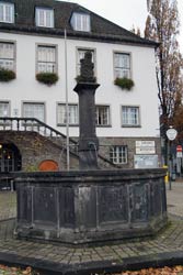 Vor dem Rathaus steht der Marktbrunnen, ein achteckiger Bau aus Basaltplatten, dessen Ursprung auf das Jahr 1331 zurückgeht. Auf der Steinernen Säule befand sich bis zum Jahre 2003 der Stadtpatron St. Engelbert und heute eine Statue des Bergischen Löwen